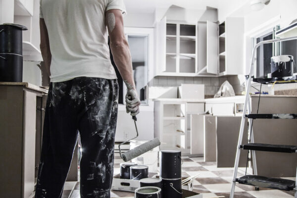 Worker painting kitchen walls during home renovation
