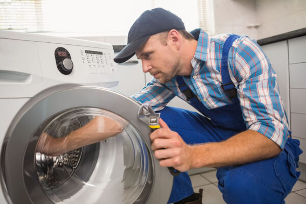 Technician repairing a front-loading washing machine