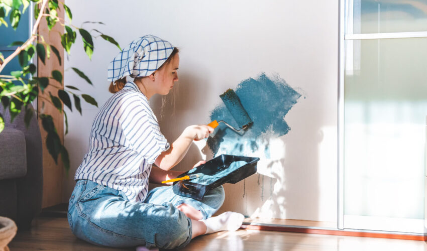 Painting services in Dubai professional painter applying blue paint on interior wall